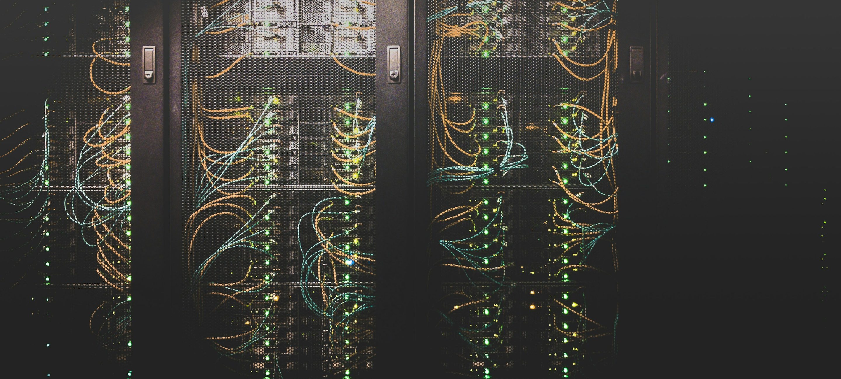 Two open cabinets photographed straight on, showing fibre routing and status indicators across every shelf