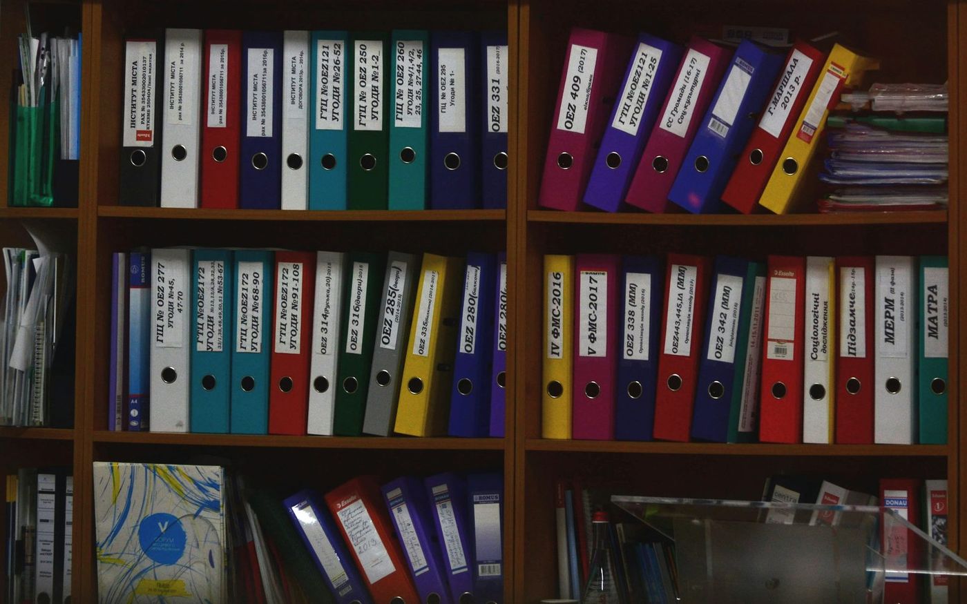 Shelves of labelled binders filed by year and reference